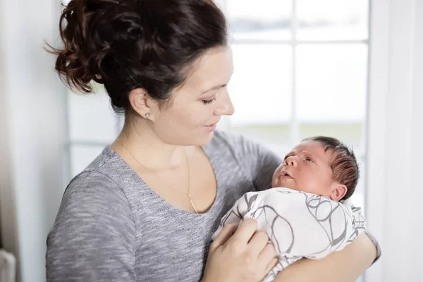 Ibu bahagia menggendong bayi manis di ruang tamu — Stok Foto