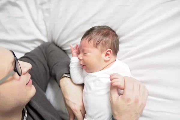 Bebê recém-nascido de duas semanas com pai na cama — Fotografia de Stock