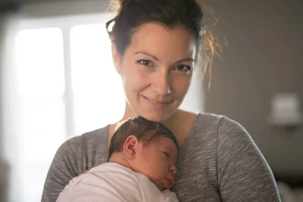 Felice madre che tiene adorabile bambino in salotto — Foto Stock