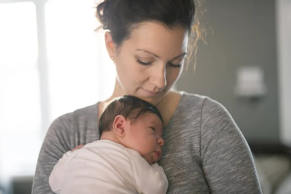 Mère heureuse tenant bébé adorable enfant sur le salon — Photo