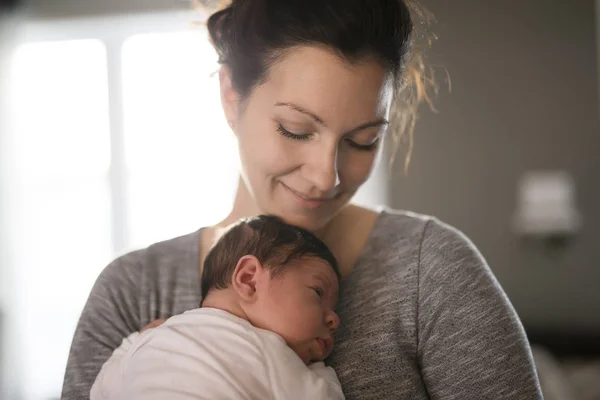 Счастливая мать держит очаровательного ребенка ребенка в гостиной — стоковое фото