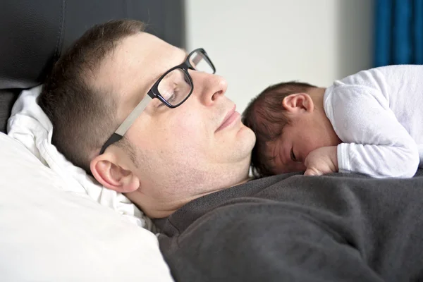 Bebê recém-nascido de duas semanas com pai na cama — Fotografia de Stock