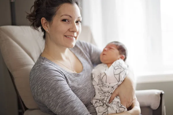 Mãe feliz segurando bebê adorável criança na sala de estar — Fotografia de Stock