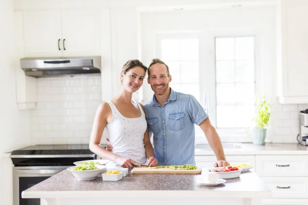 Casal na cozinha fazendo salada juntos — Fotografia de Stock