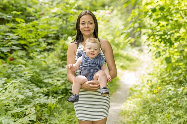 Playful woman in the garden playing with her baby son — Stock Photo, Image