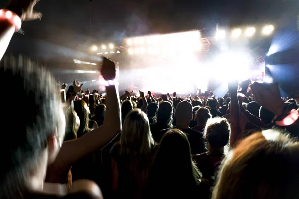 音乐会的剪影人群在明亮的舞台灯光。黑暗的背景，烟雾，音乐会聚光灯 — 图库照片