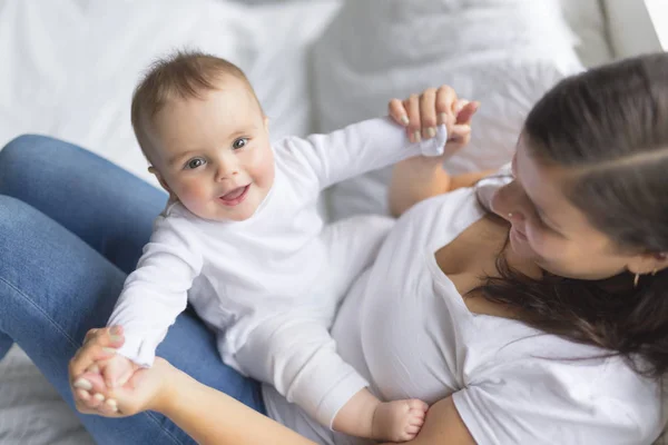 Feliz familia amorosa. Madre jugando con su bebé en el dormitorio. — Foto de Stock