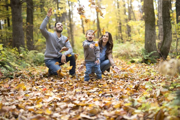 Lyckliga familjen koppla av utomhus i höst park — Stockfoto