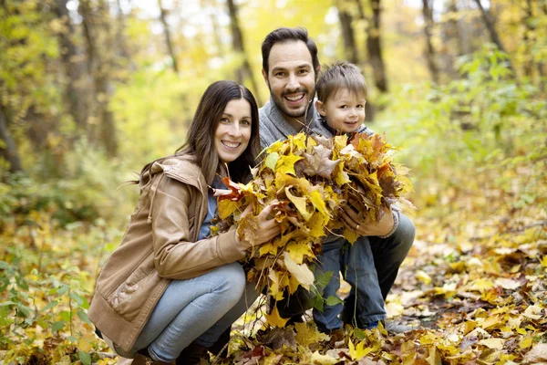 Lyckliga familjen koppla av utomhus i höst park — Stockfoto