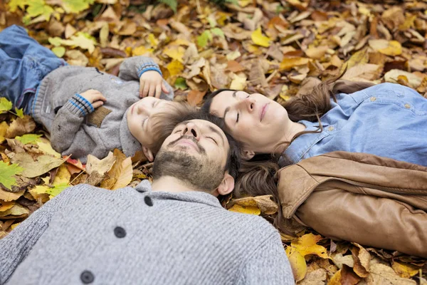 Familia feliz relajándose al aire libre en el parque de otoño —  Fotos de Stock