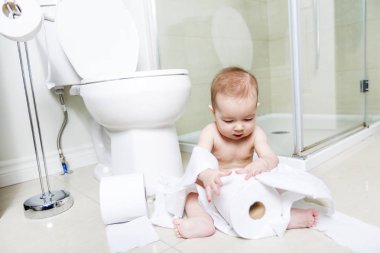 Toddler ripping up toilet paper in bathroom clipart