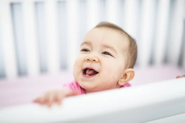 Infant baby resting and playing in his little baby bed — Stock Photo, Image