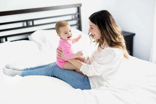 Mère et bébé enfant sur un lit blanc . — Photo