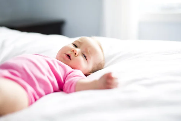 Bambina sdraiata su lenzuolo bianco — Foto Stock