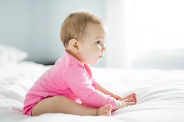 Bebê menina sentar na folha branca — Fotografia de Stock