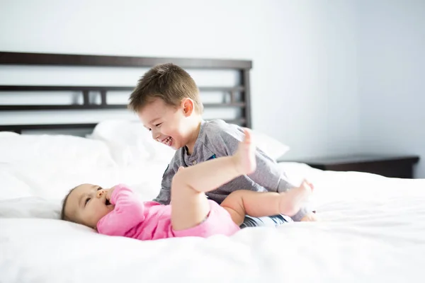 Bebê e seu irmão na cama — Fotografia de Stock