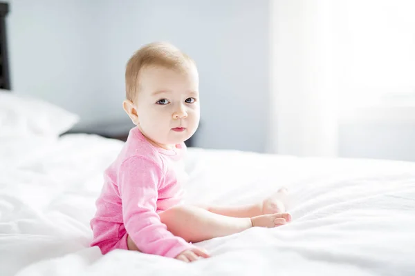 Bébé fille assis sur feuille blanche — Photo