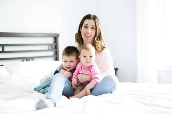 행복 가족 어머니와 두 아이, 아들과 딸이 침대에서 — 스톡 사진