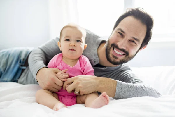 Feliz padre jugando con adorable bebé en el dormitorio — Foto de Stock