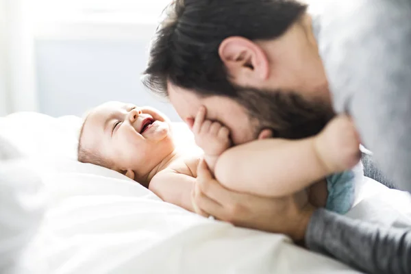 Feliz padre jugando con adorable bebé en el dormitorio — Foto de Stock