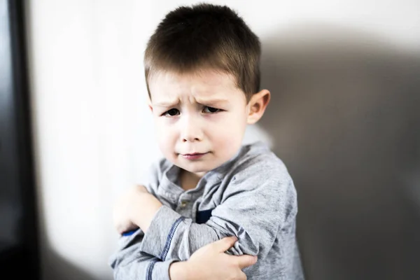 Niño sentado solo apoyado en la pared — Foto de Stock