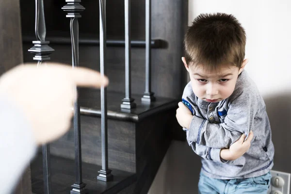 Jongen zit alleen leunt op de muur met de vuist van de vader. — Stockfoto