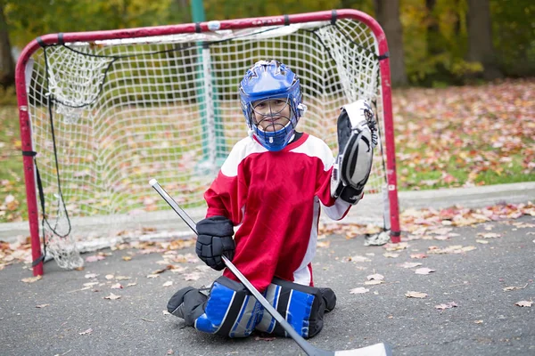 Мальчик одет, чтобы быть вратарем в игре уличный хоккей — стоковое фото