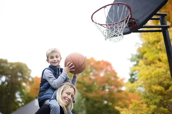 mother play basketball with his son