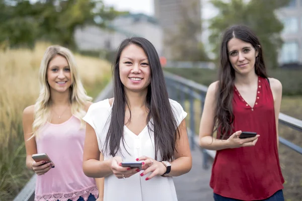 Mulheres encantadoras com celular fora na cidade — Fotografia de Stock