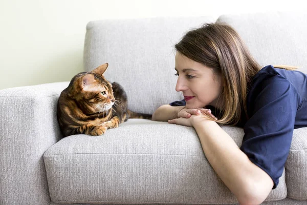Katze und Frau im Wohnzimmer auf der Couch — Stockfoto