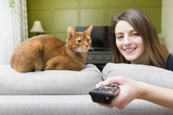 Tyttö katsomassa televisiota kissan kanssa — kuvapankkivalokuva