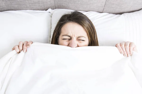 Giovane donna addormentata in camera da letto a casa indossando in bianco — Foto Stock