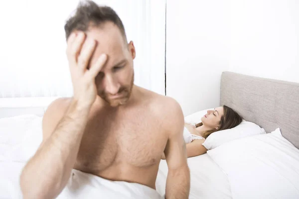 Homme déprimé assis sur le bord du lit dans la chambre — Photo