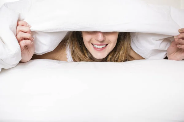 Giovane donna addormentata in camera da letto a casa indossando in bianco — Foto Stock