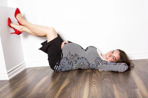 Беременная женщина лежит на полу — стоковое фото