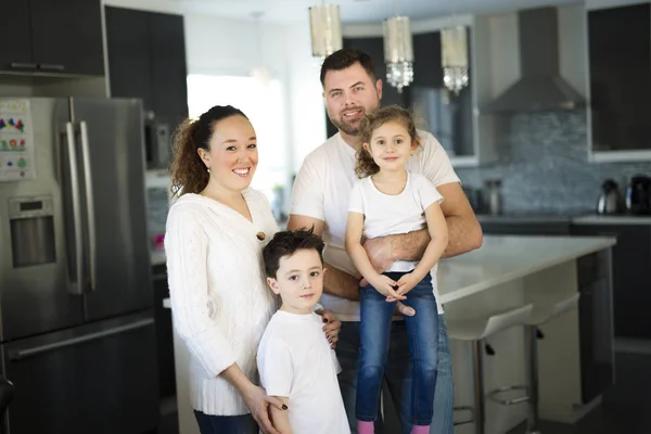 Retrato de una familia feliz de cuatro en la cocina en casa — Foto de Stock