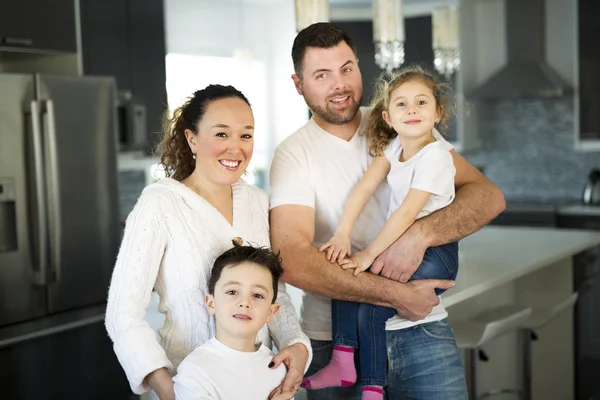 Retrato de uma família feliz de quatro na cozinha em casa — Fotografia de Stock