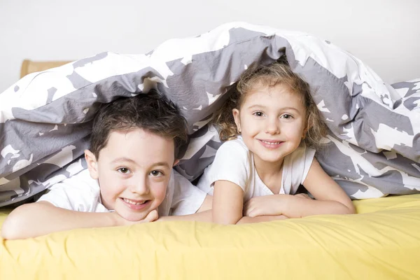 Bror och syster avkopplande tillsammans i sängen — Stockfoto