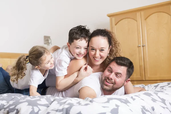 Famille, enfants et concept de la maison - famille heureuse avec deux enfants sous couverture à la maison — Photo