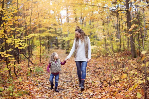 Junge Mutter spielt mit ihrer Tochter im Herbstpark — Stockfoto