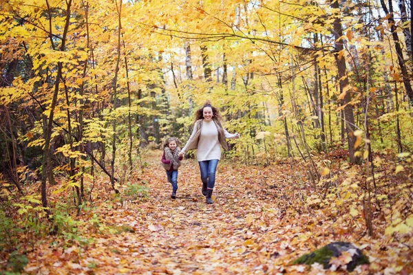 Joven madre jugando con su hija en el parque de otoño — Foto de Stock