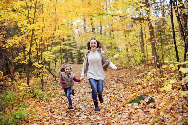 Młoda matka bawi się z córką w jesiennym parku — Zdjęcie stockowe