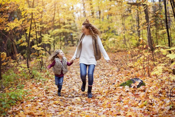 Junge Mutter spielt mit ihrer Tochter im Herbstpark — Stockfoto