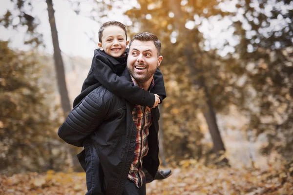 Père et fils s'amusent dans le parc d'automne — Photo