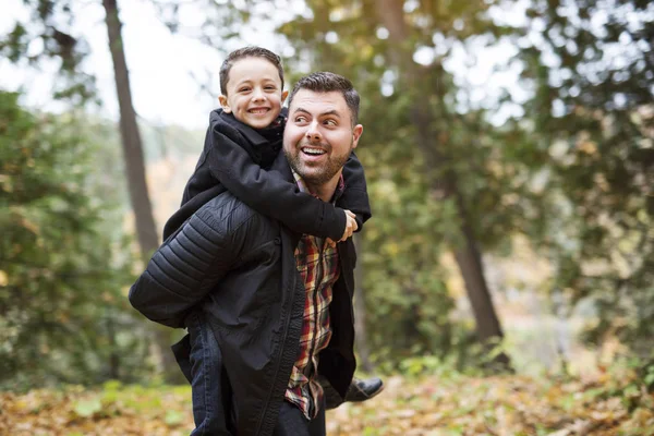 Père et fils s'amusent dans le parc d'automne — Photo