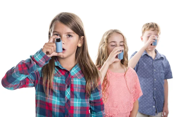 Tres niños usando inhalador para el asma. Fondo blanco —  Fotos de Stock