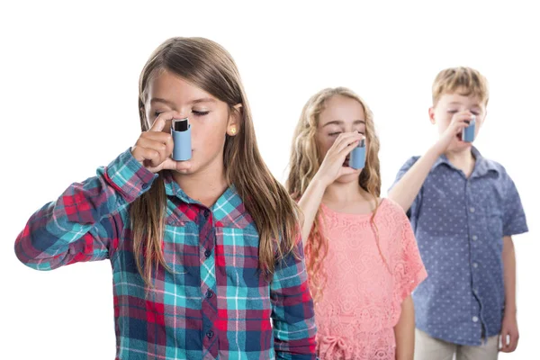 Tres niños usando inhalador para el asma. Fondo blanco —  Fotos de Stock