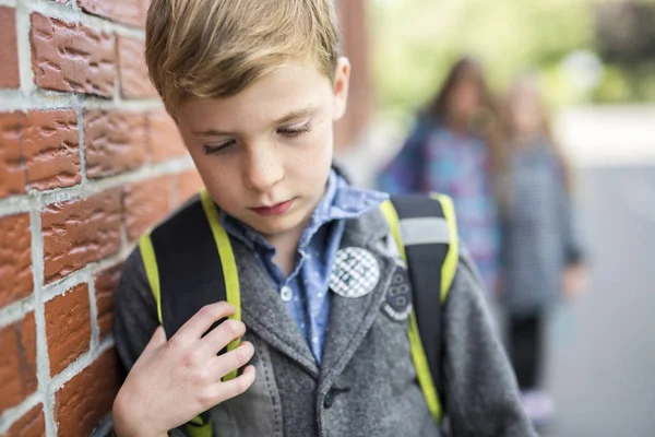 Elèves amis taquiner un élève seul école primaire — Photo