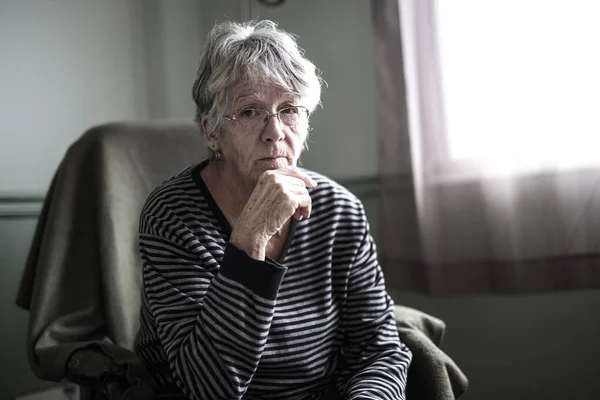 worried senior woman at home felling very bad