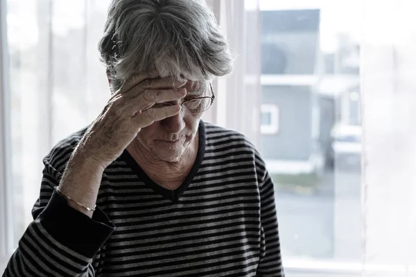 Worried senior woman at home felling very bad — Stock Photo, Image